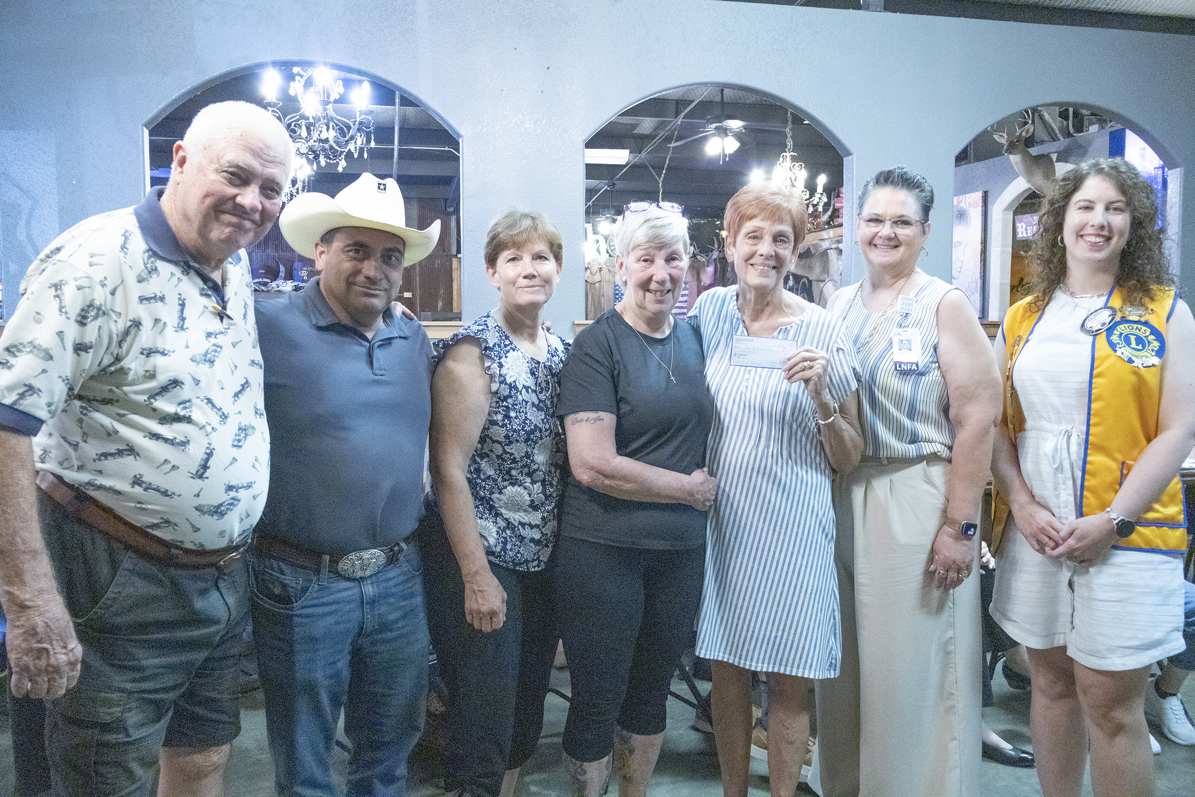 Photo cutline: Several members of the Gatesville Sleep in Heavenly Peace’s Core team posed with Gatesville Lions Club President Shawnee Miller (right) after being presented with a check during the club’s Aug. 26 meeting. 