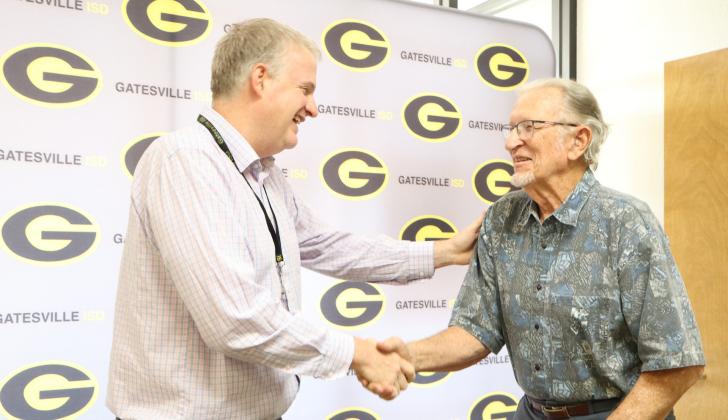 Gatesville ISD Superintendent Barrett Pollard (left) shakes hands with former educator Coach Elton Ramthun (right) during the Hornet Legend Spotlight section of the June 22 School Board meeting. Gatesville Messenger/Ally Hinkle