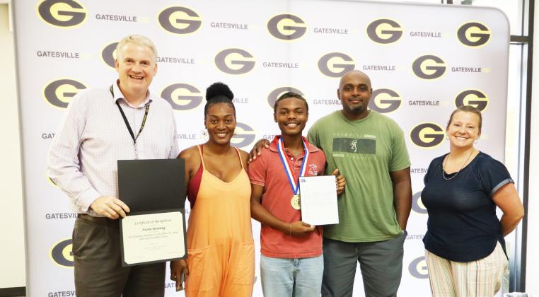 GISD Superintendent Barrett Pollard (far left) and Choral Director Cherith Wells (far right) pose with Nevin Benning (middle) and his family during the Student Spotlight portion of the Monday, June 22, School Board meeting. Gatesville Messenger/Ally Hinkle