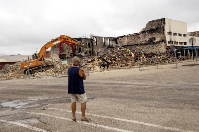 A Freedom Bail Bonds owner JW Bear watches as the demoliton continues on the downtown square where his building and office once stood. A fire on March 16, destroyed the entire block on South 6th street. CCLP/DAVID MORRIS