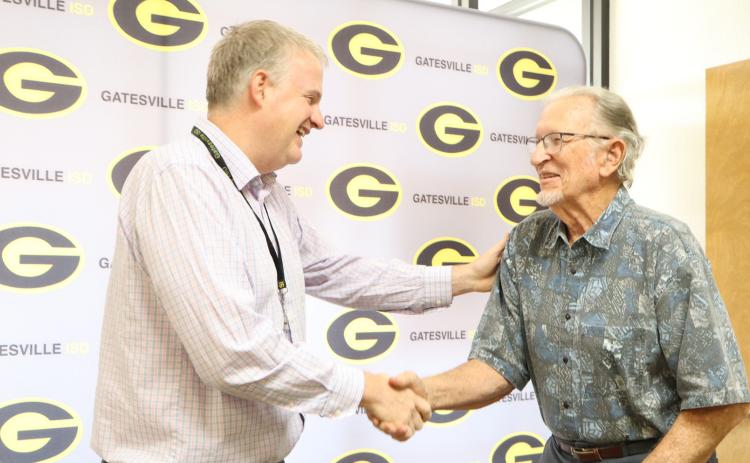 Gatesville ISD Superintendent Barrett Pollard (left) shakes hands with former educator Coach Elton Ramthun (right) during the Hornet Legend Spotlight section of the June 22 School Board meeting. Gatesville Messenger/Ally Hinkle