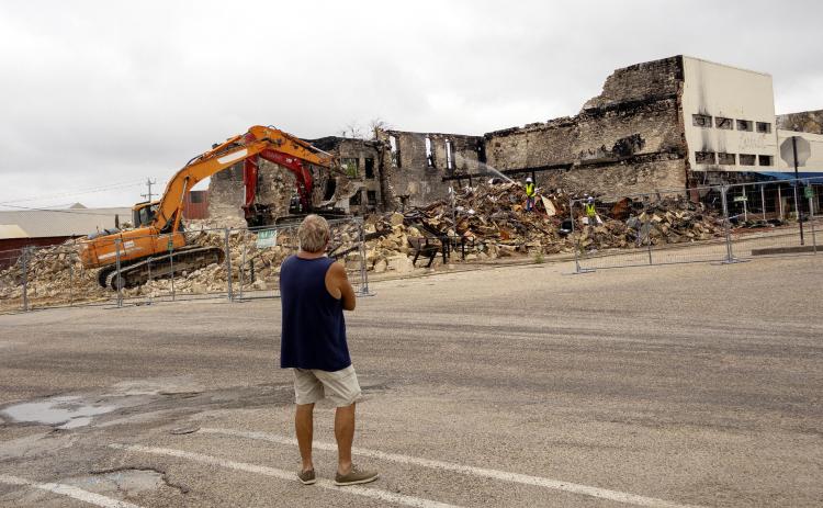 A Freedom Bail Bonds owner JW Bear watches as the demoliton continues on the downtown square where his building and office once stood. A fire on March 16, destroyed the entire block on South 6th street. CCLP/DAVID MORRIS