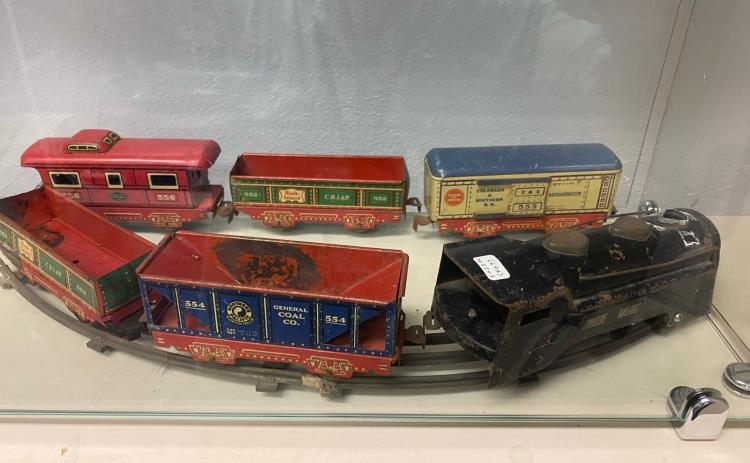 A small metal train, possibly from the 1950s, is on display in the Toy Exhibit.